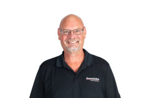 Male, Caucasian; Black polo shirt with CLE logo; Bald with glasses; Beard and moustache