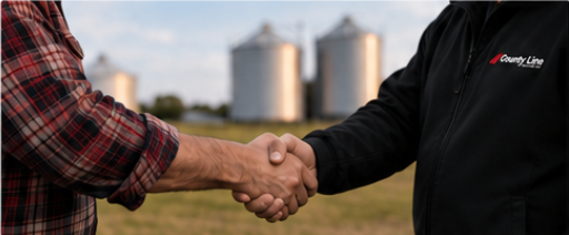 Two people shaking hands on a farm with grain silos in the background, representing a new chapter for County Line Equipment.